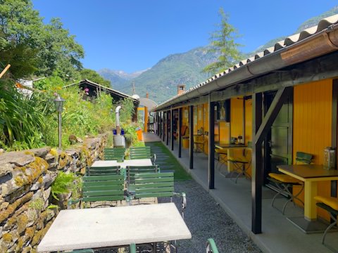 Schöne Aussensitzplätze beim Baracca Backpacker Hostel in Aurigeno Tessin